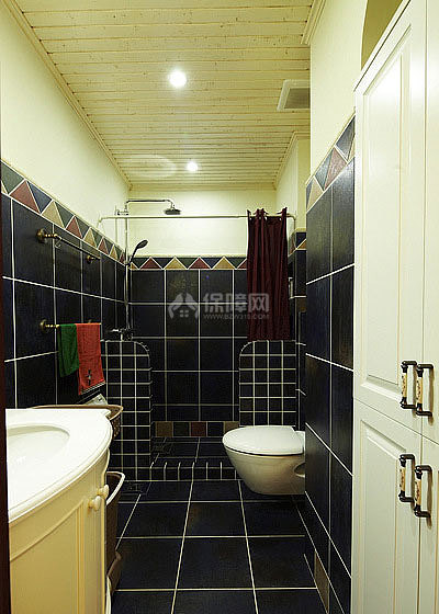卫生间采用黑色的瓷砖铺饰，配上洁白的卫浴，黑白搭配