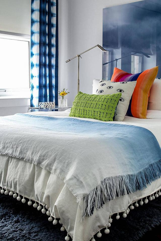 蓝色的舒适床铺,配以雪佛龙图案的时髦地毯,可用于小卧室