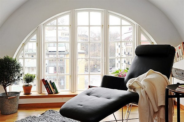 舒适的一个角落，圆弧形的落地窗、矮矮的地台、原木色