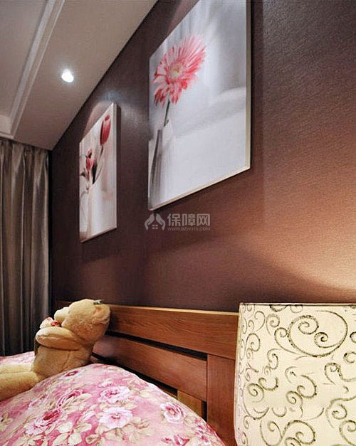 床頭墻面上掛著兩幅花畫(huà)，床套也是布滿花朵的圖案，陶