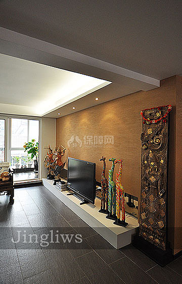 白色的地台直接取代了电视柜，地台上放了不少摆件，都