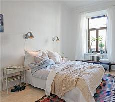 彩色方格的地毯点亮了浅色调的卧室空间